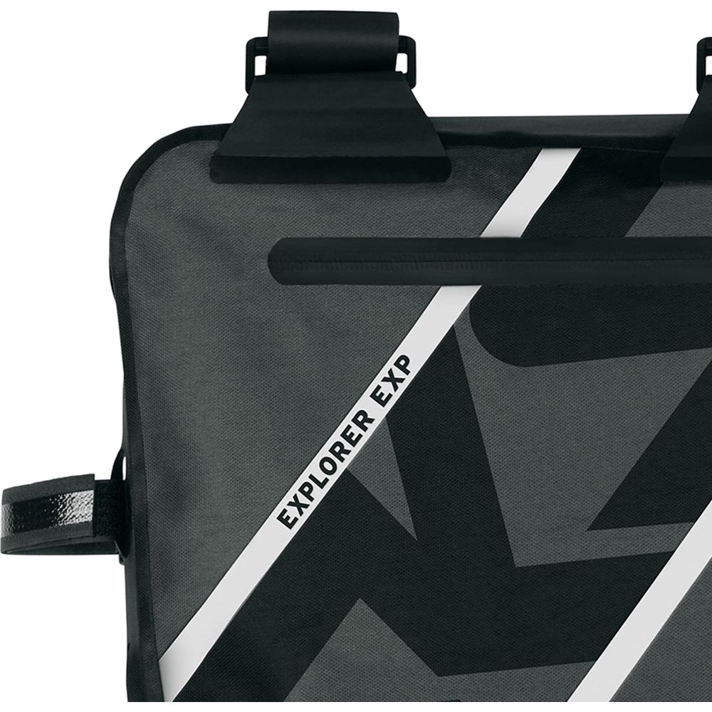 Graue Tasche mit schwarzen Riemen und weißem Streifen mit Text.