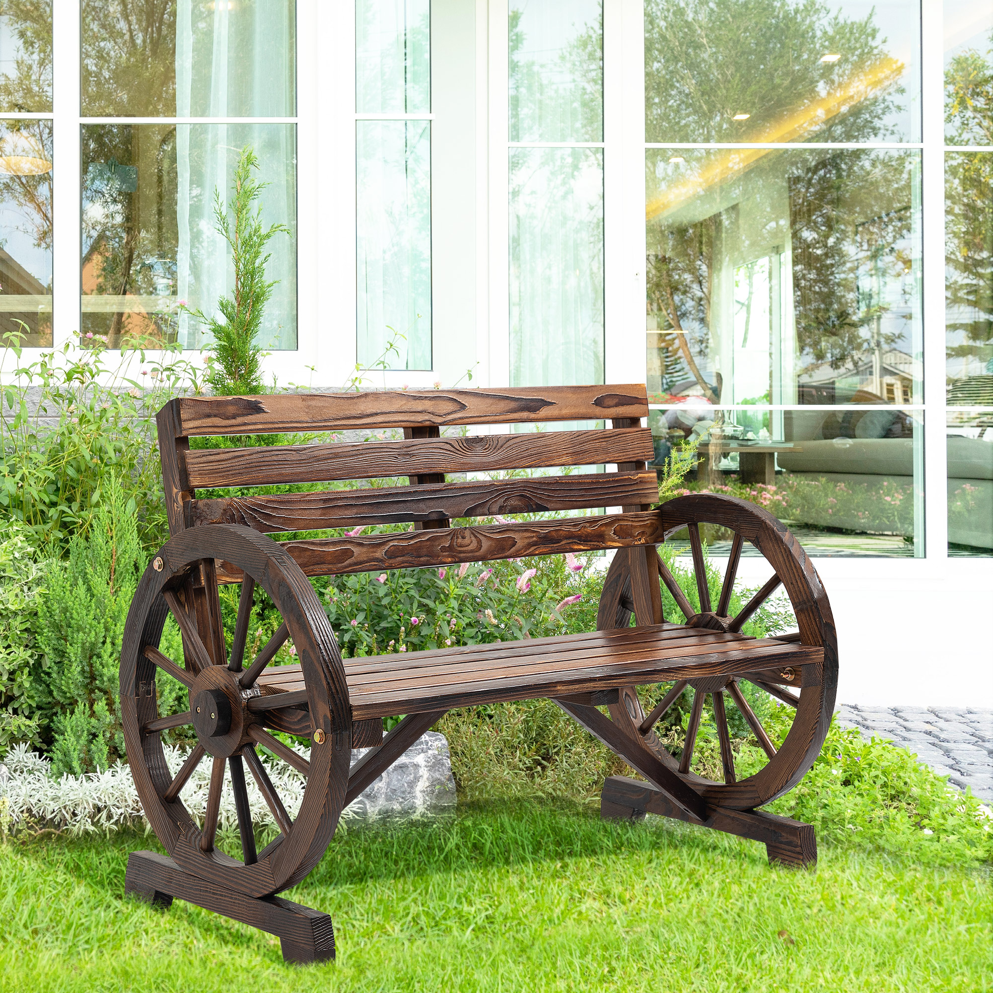 Eine hölzerne Gartenbank mit Wagenrad-Seiten, auf einem grünen Rasen.