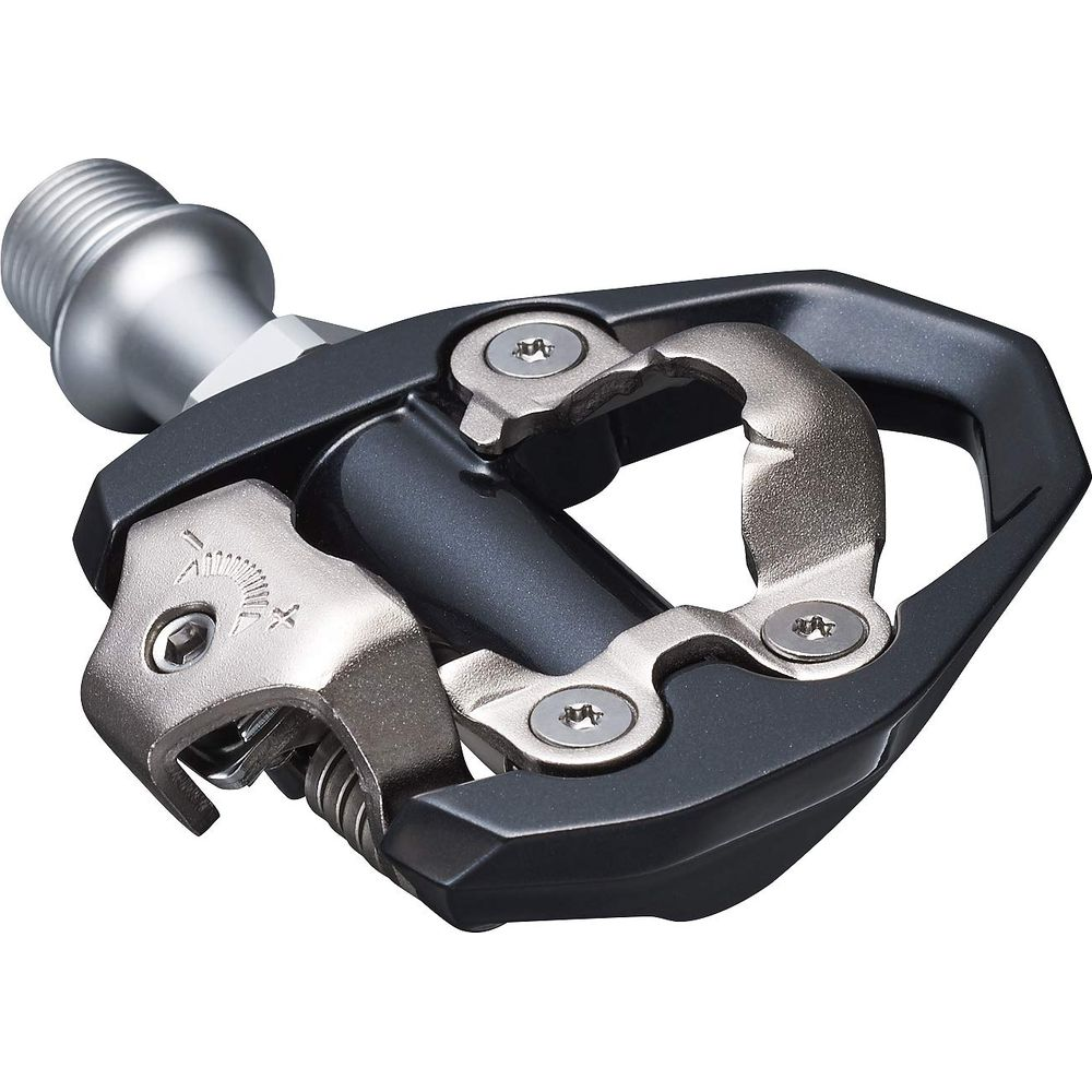 Ein schwarzer Fahrradpedal mit silbernen Metallelementen im Detail.
