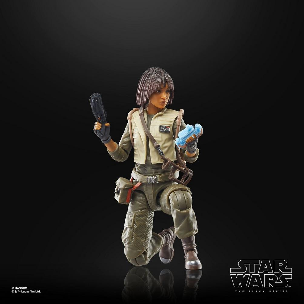 Una action figure femminile in ginocchio tiene un blaster e un oggetto blu.