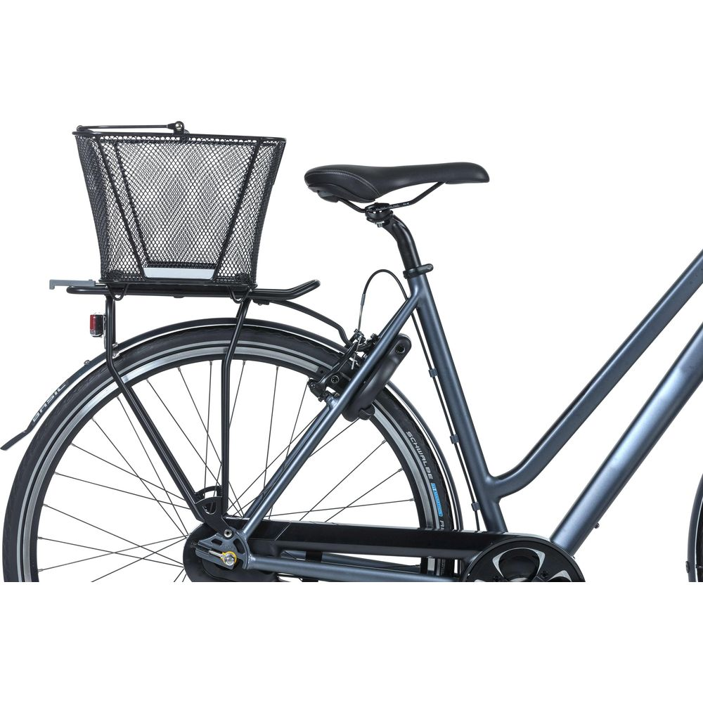 Un vélo sombre avec un panier en fil métallique à l'avant et un porte-bagages à l'arrière.