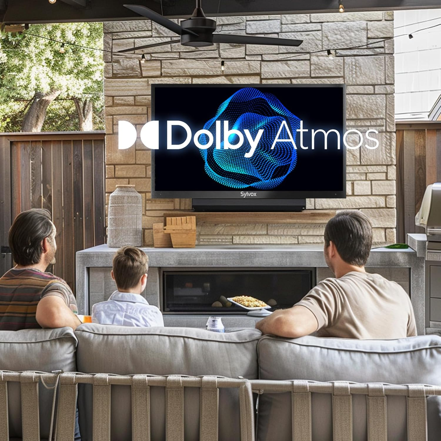 Drei Personen sitzen auf einer Couch und schauen auf einen Fernseher mit Dolby Atmos-Logo.