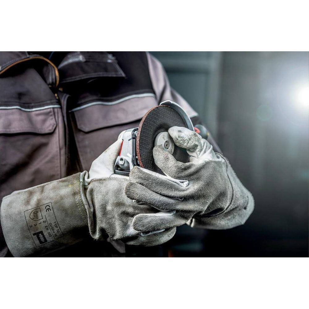 Personne avec gants de protection tenant une meuleuse d'angle.