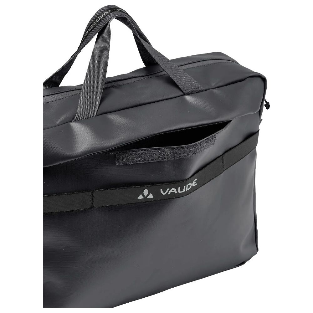 Sac noir avec poignées et logo VAUDE. Une poche est ouverte.