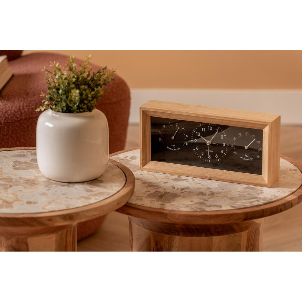 Une boîte en bois avec une horloge, un thermomètre et un hygromètre sur une table en marbre.