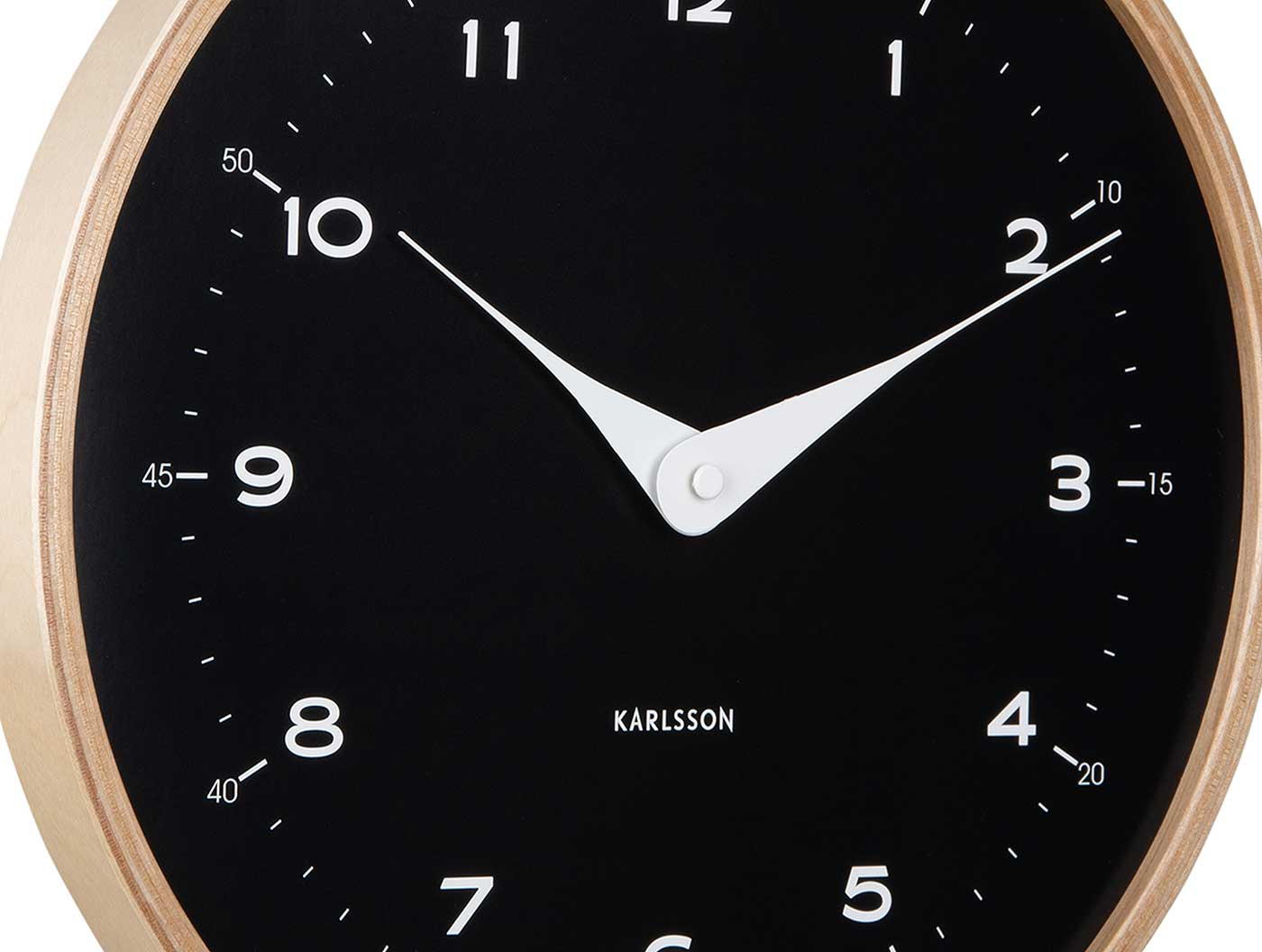 Eine Nahaufnahme einer runden Wanduhr mit schwarzem Zifferblatt und weißen Zeigern.