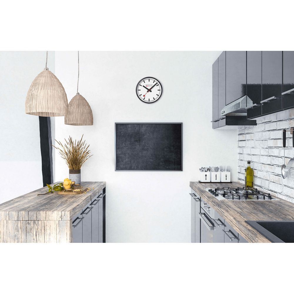 Cucina moderna con piani di lavoro in legno, fornello a gas, cappa e orologio da parete.