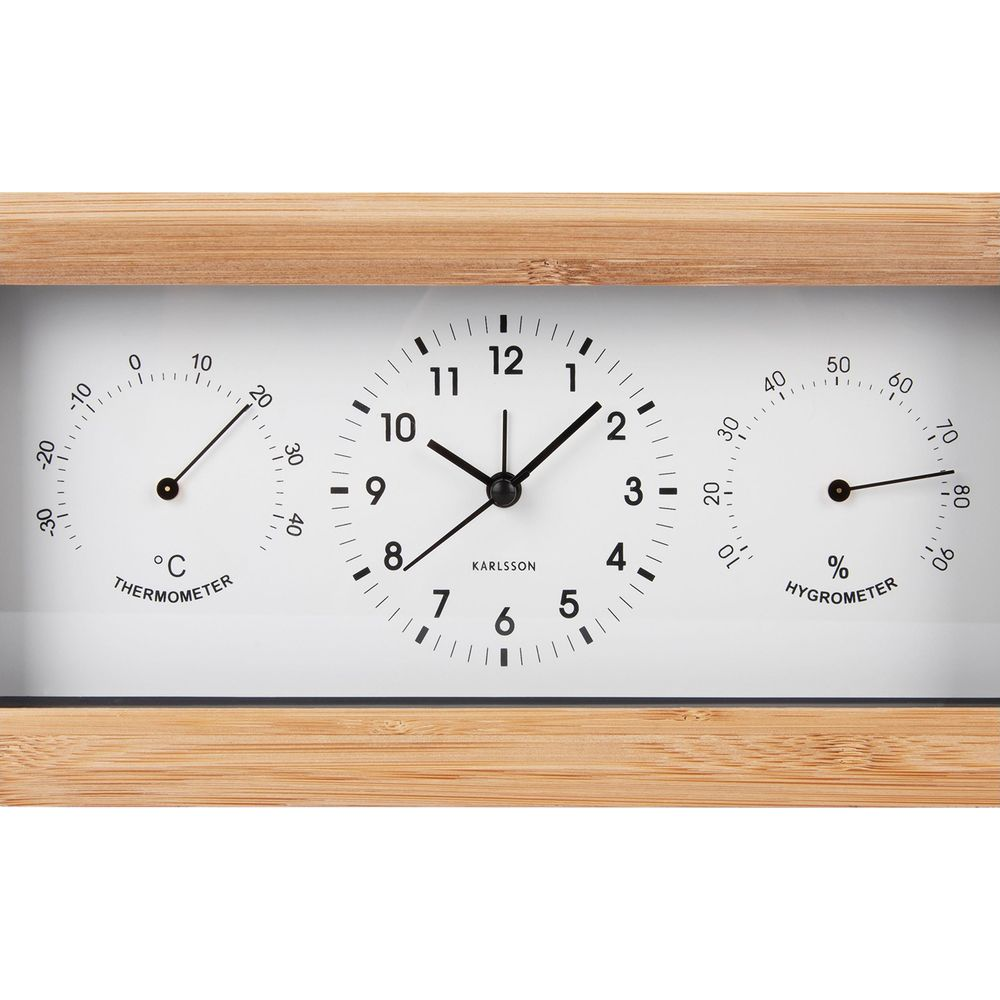 Un cadre en bois montre une horloge, un thermomètre et un hygromètre.
