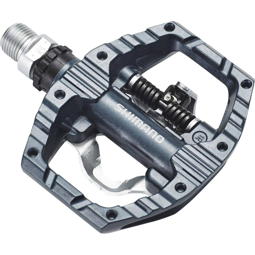 Dunkelgraues Fahrradpedal mit Shimano-Logo und Federmechanismus.