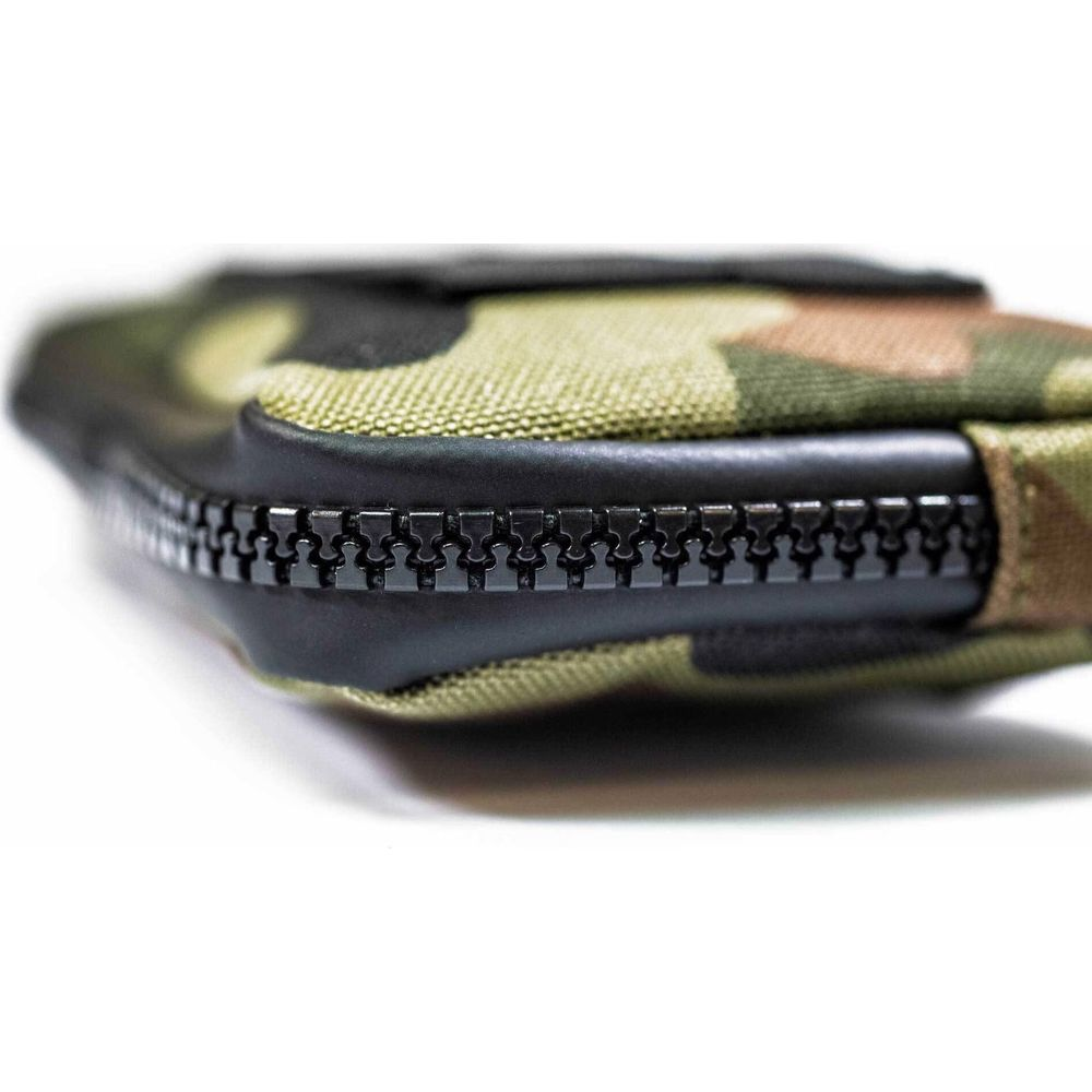 Gros plan d'une pochette camouflage avec fermeture éclair noire sur fond blanc.
