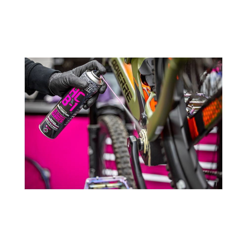 Hand sprüht Fahrradkette mit Schmiermittel auf. Nahaufnahme.