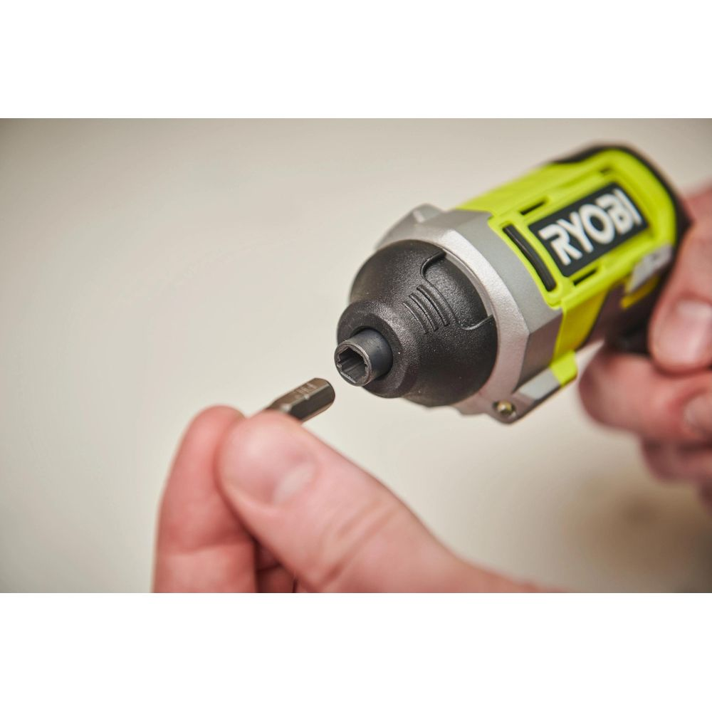 Eine Hand hält einen Schraubendreher-Bit, eine andere Hand hält einen gelben Ryobi-Akkuschrauber.