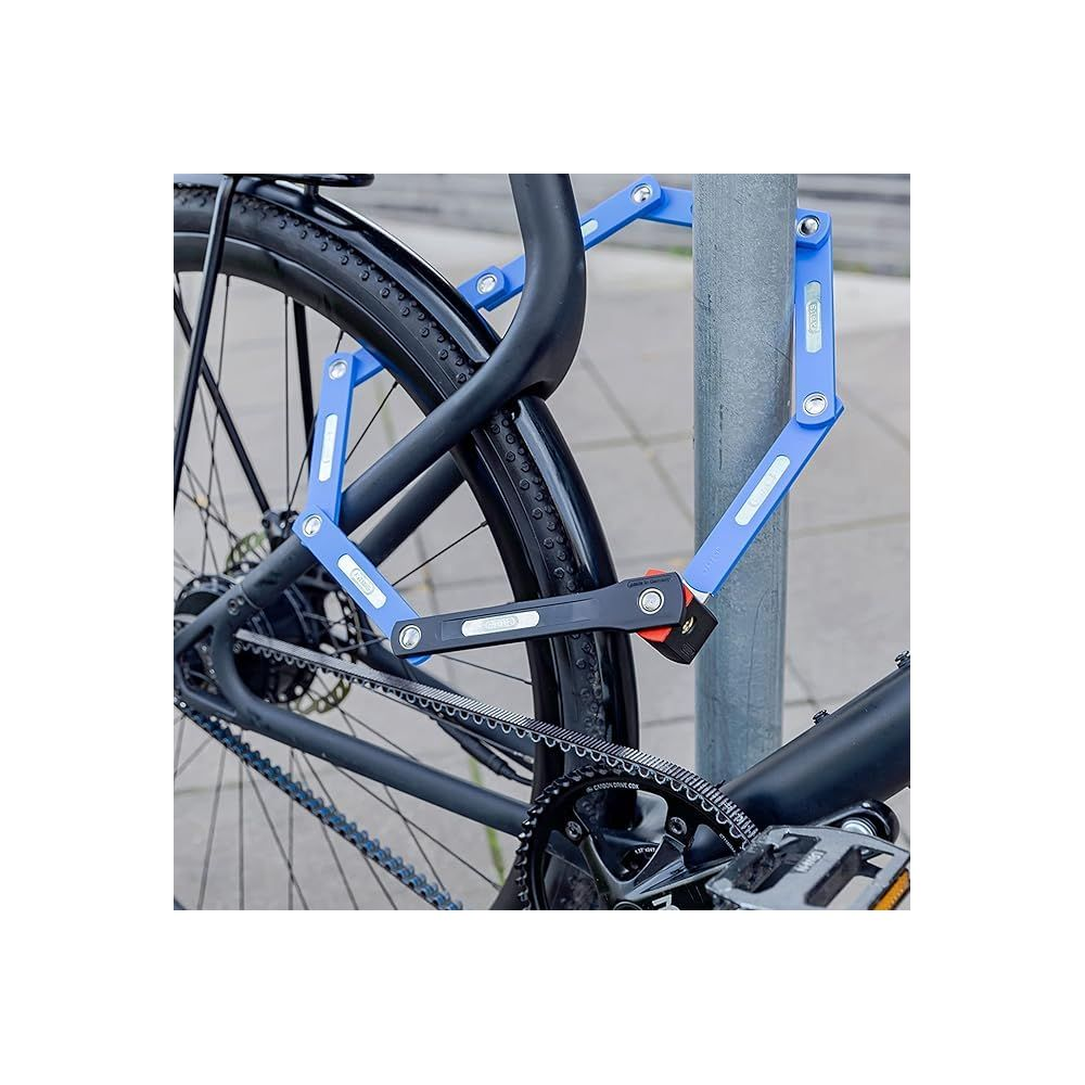 Ein blaues Faltschloss sichert ein Fahrrad an einem grauen Pfosten.