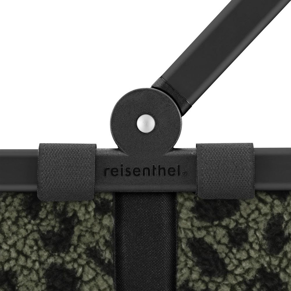 Une poignée noire avec le logo "reisenthel" sur un tissu à motif.