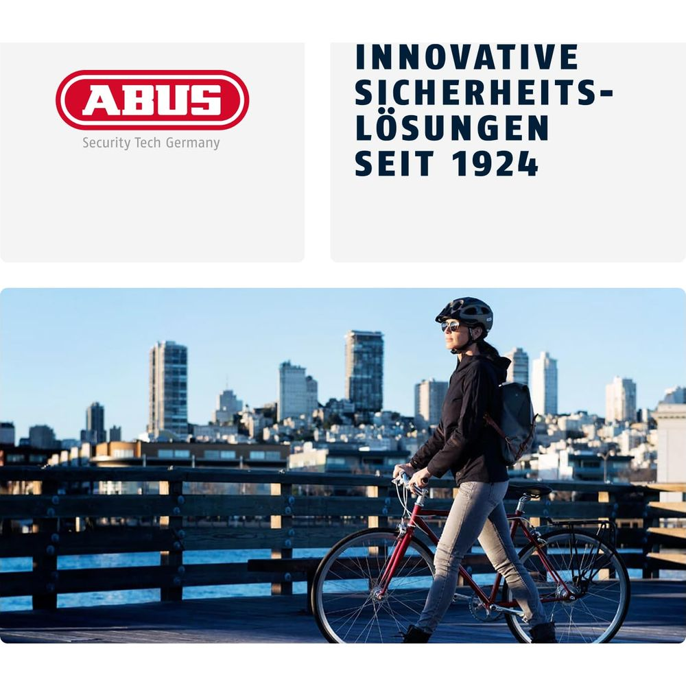 Mann mit Fahrrad auf Pier vor Stadtkulisse