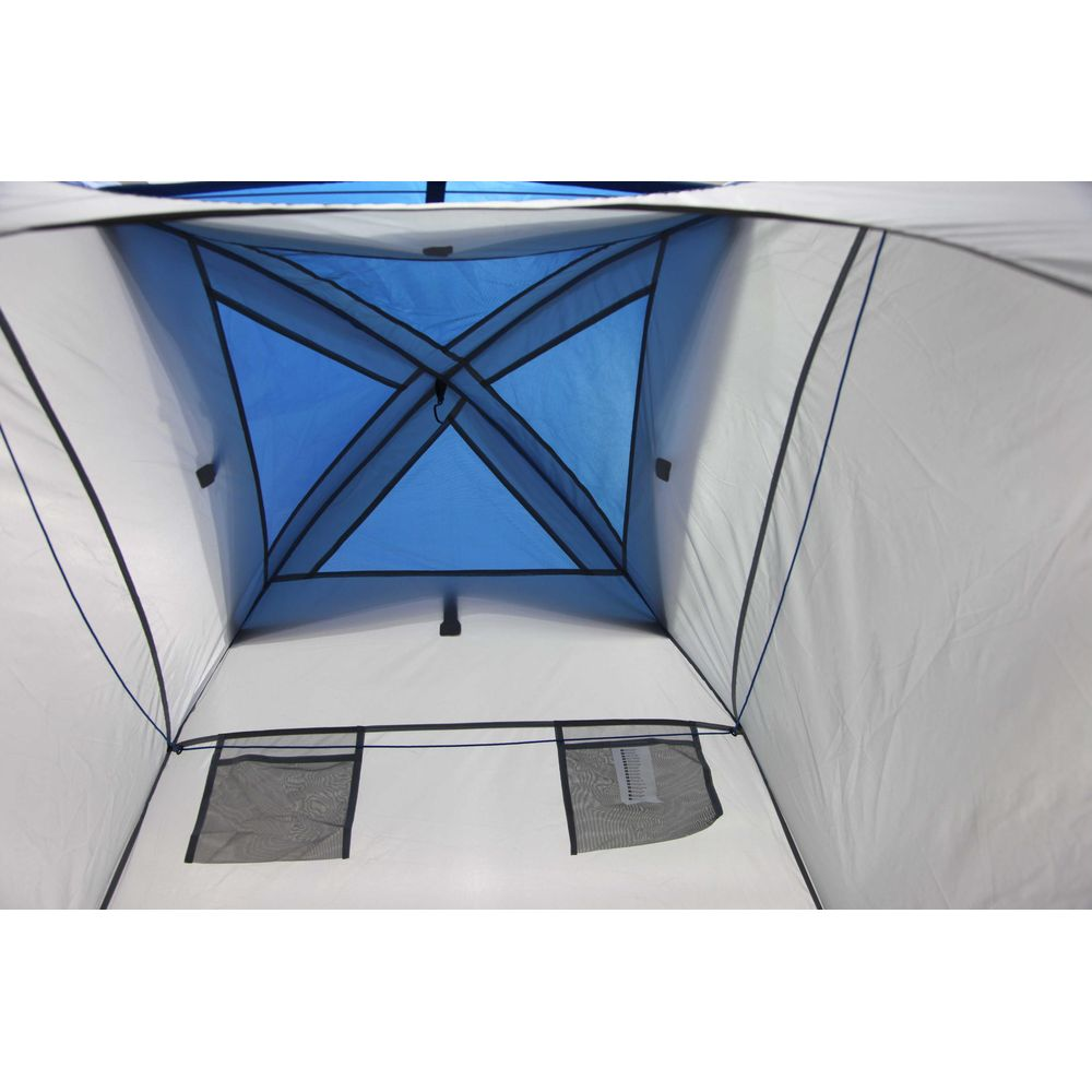 Vista interna di una tenda bianca con soffitto blu e due finestre in rete.