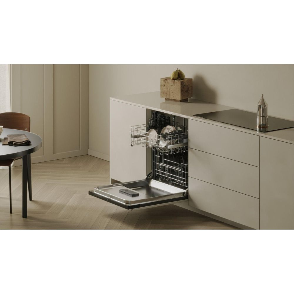 Una lavastoviglie aperta con piatti all'interno in un ambiente di cucina moderno.
