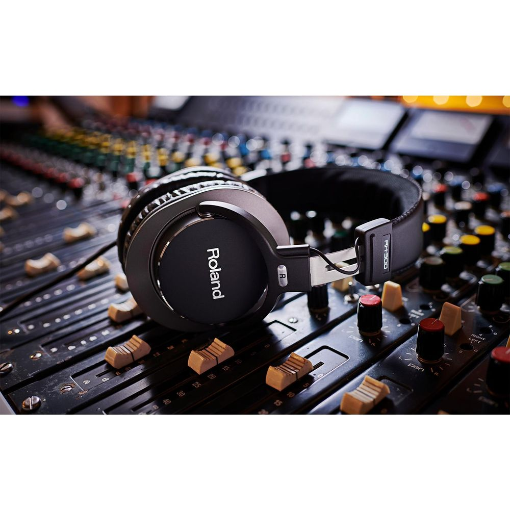 Casque Roland noir posé sur une console de mixage.