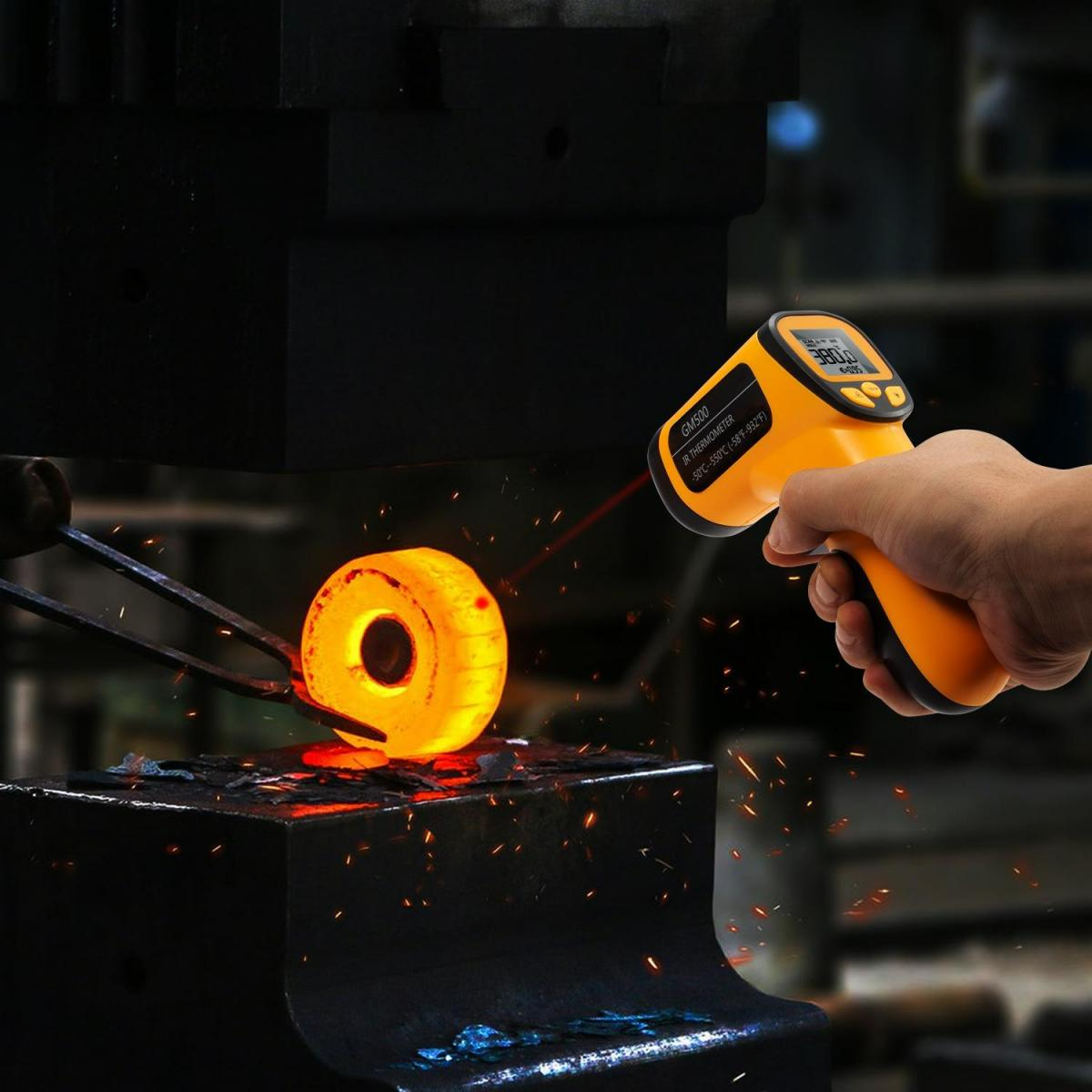 Ein gelber IR-Thermometer misst die Temperatur eines glühenden Metallstücks.