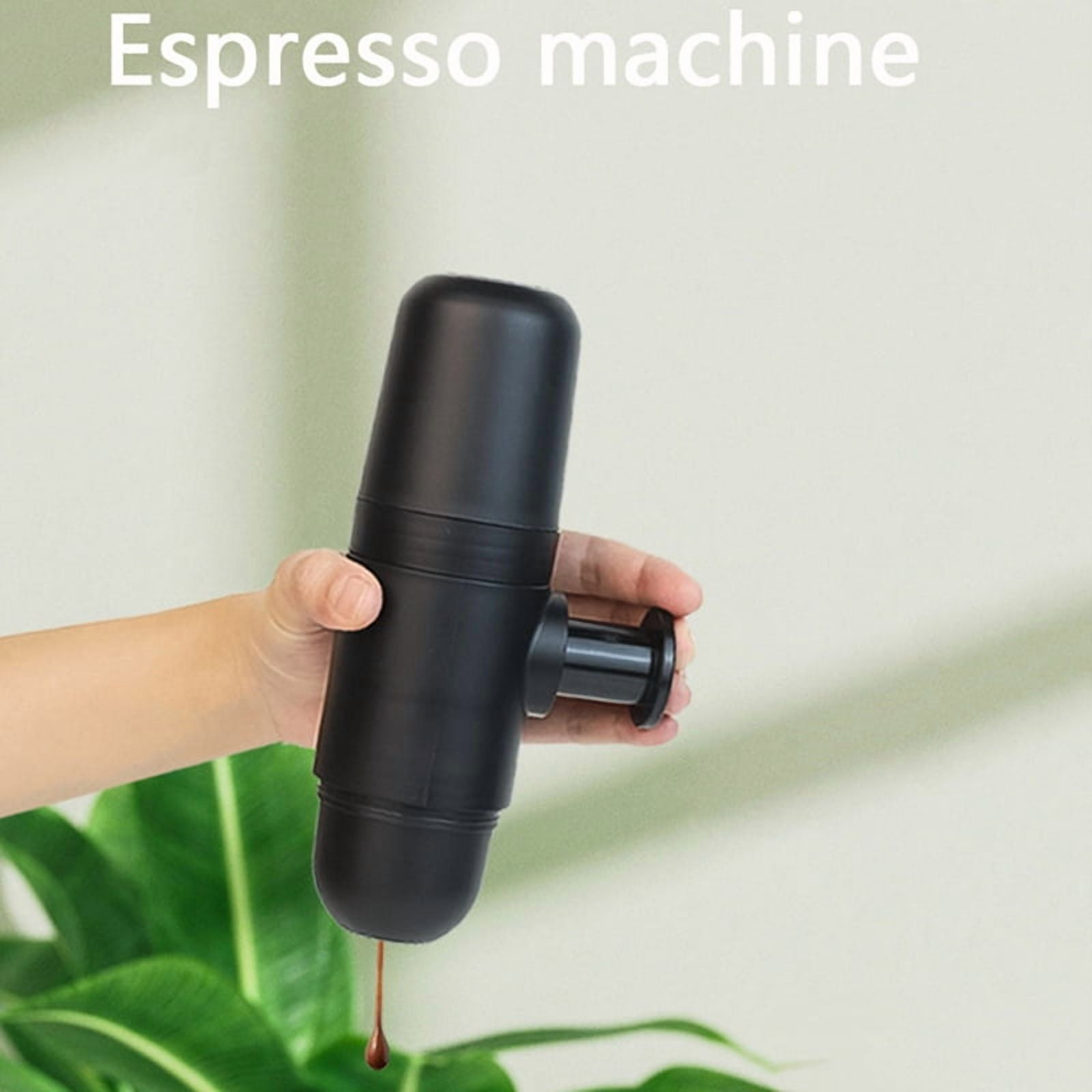 Eine Hand hält eine schwarze Espressomaschine, aus der ein Tropfen Kaffee fällt.
