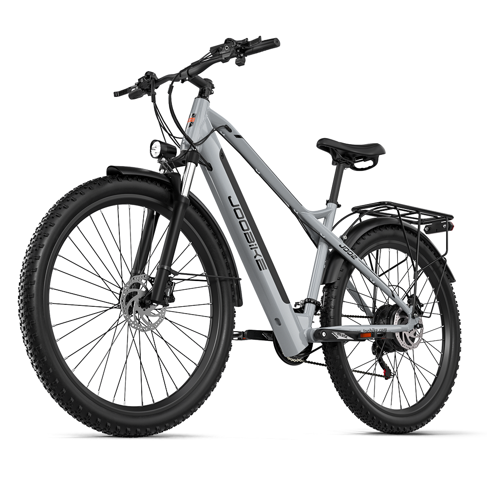 Szary rower elektryczny z szerokimi oponami, amortyzowanym widelcem i bagażnikiem.