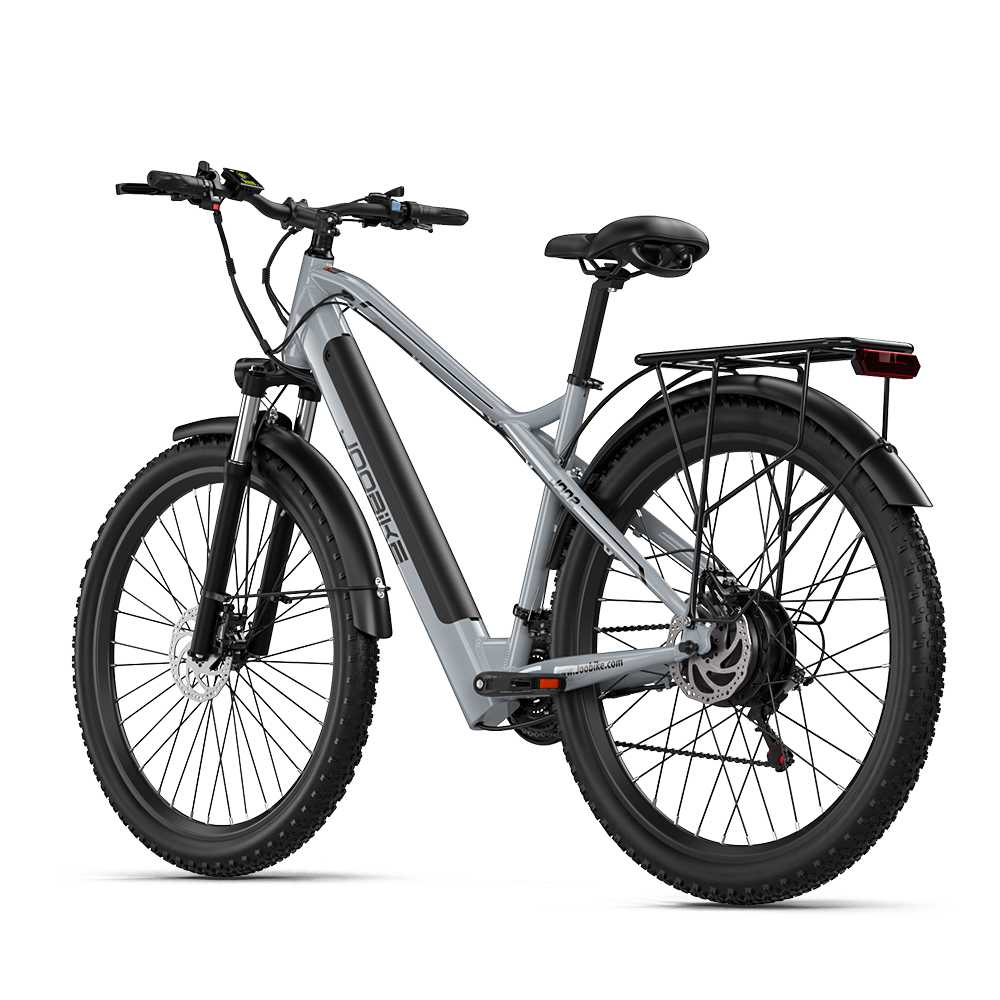 Szary rower elektryczny z szerokimi oponami, bagażnikiem i czarnym siodełkiem na czarnym tle.