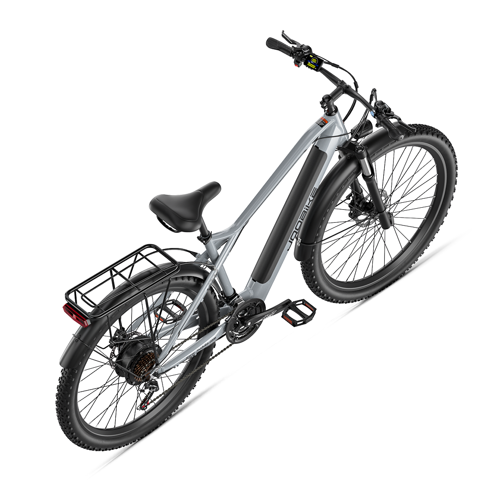 Srebrny rower elektryczny z czarnym bagażnikiem i szerokimi oponami na czarnym tle.