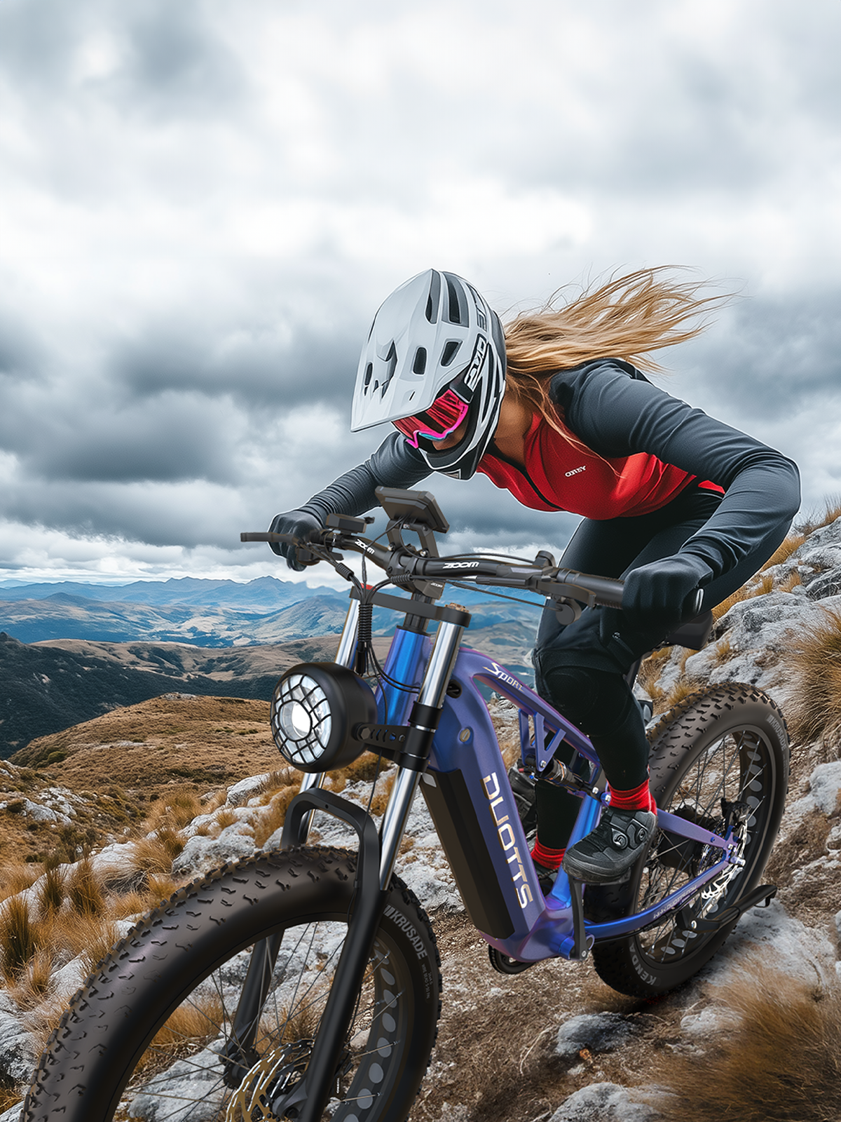 Eine Frau fährt ein E-Bike auf einem felsigen Bergpfad mit bewölktem Himmel.
