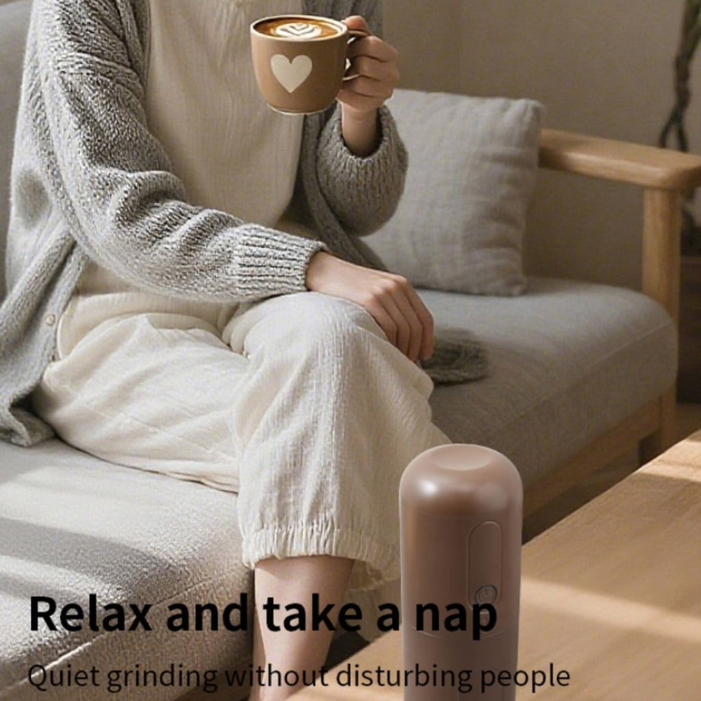 Eine Person hält eine Kaffeetasse mit Herzdesign auf einer Couch. Ein kleines braunes Gerät steht auf dem Tisch.