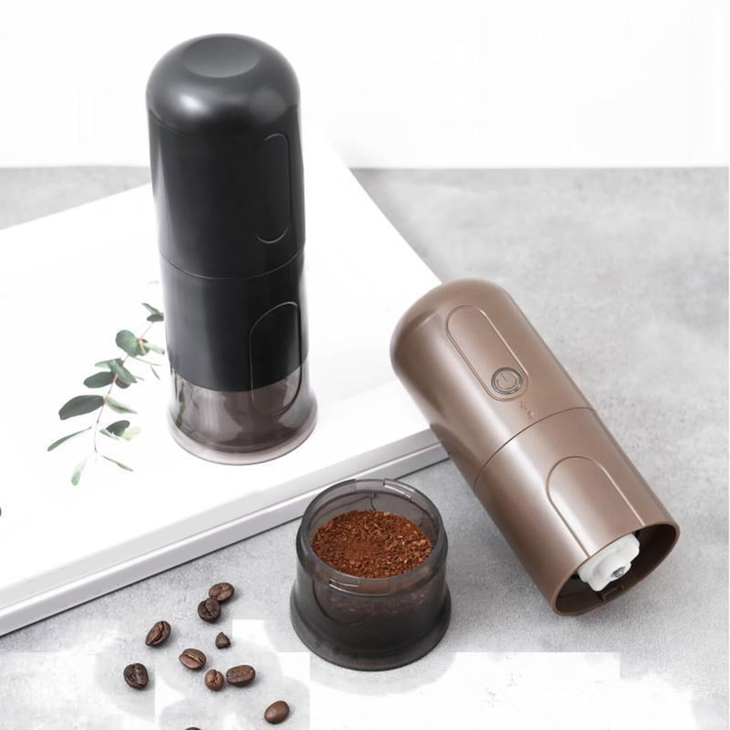 Zwei elektrische Kaffeemühlen, eine schwarz, eine braun, mit Kaffeebohnen und gemahlenem Kaffee.