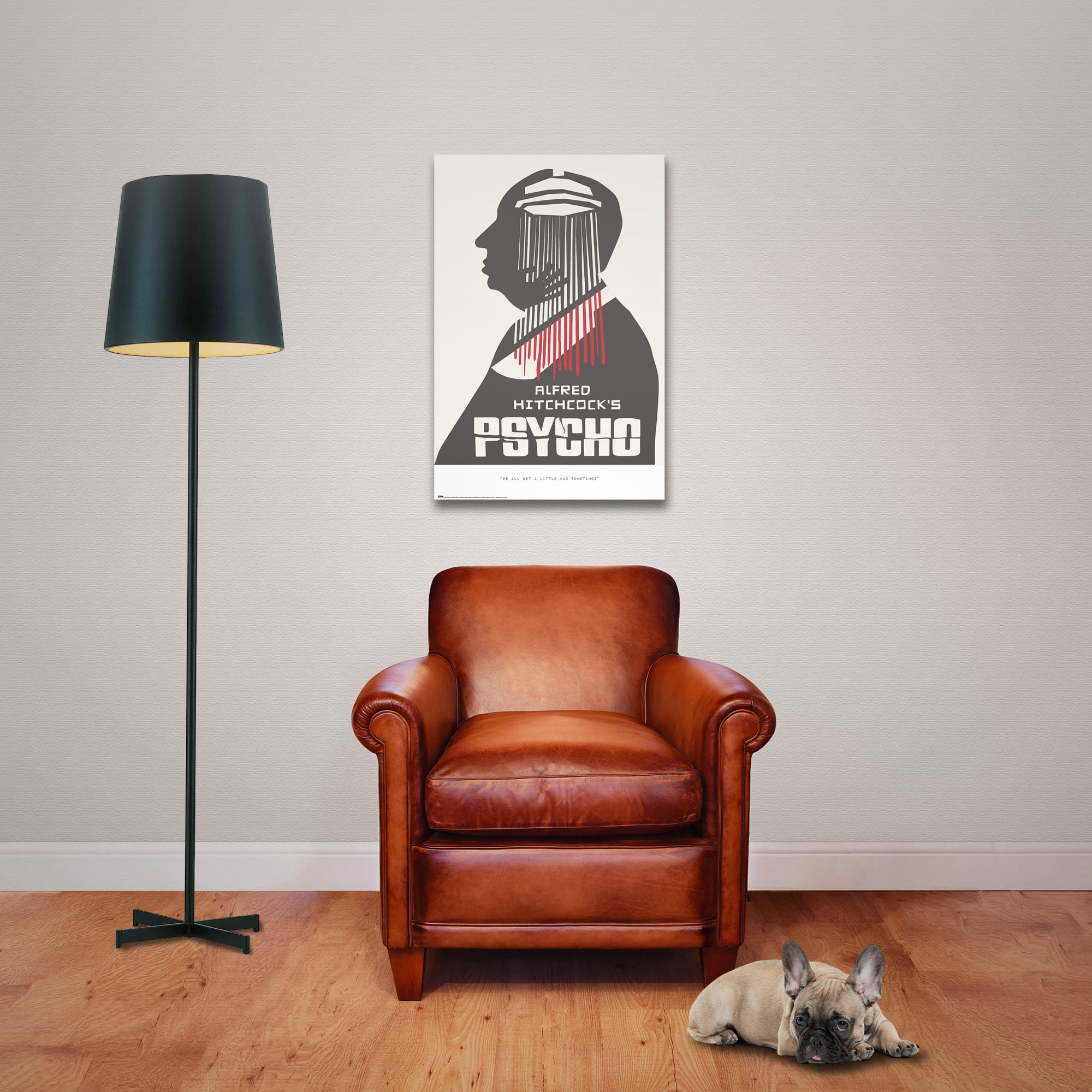 Ein Hund liegt neben einem Ledersessel unter einem Poster von Hitchcocks Psycho.