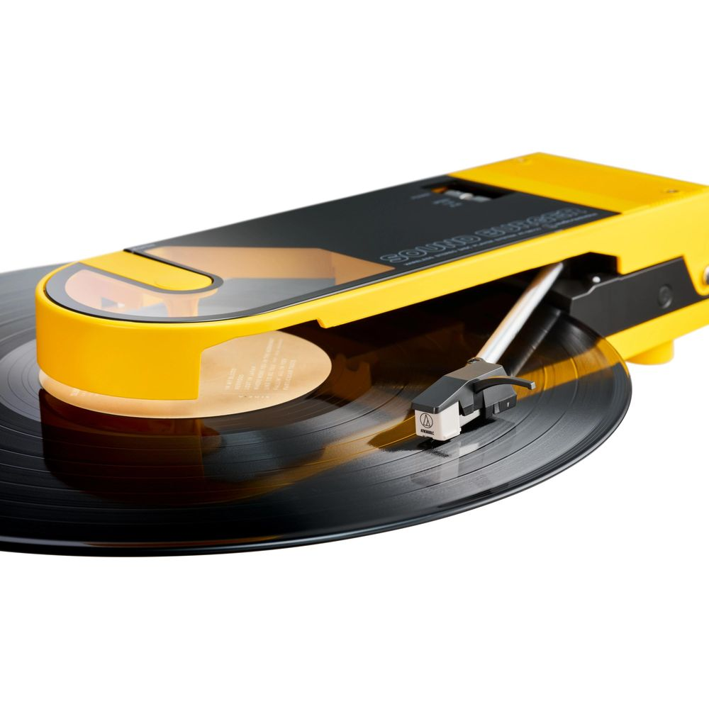 Tocadiscos amarillo con aguja negra sobre vinilo.