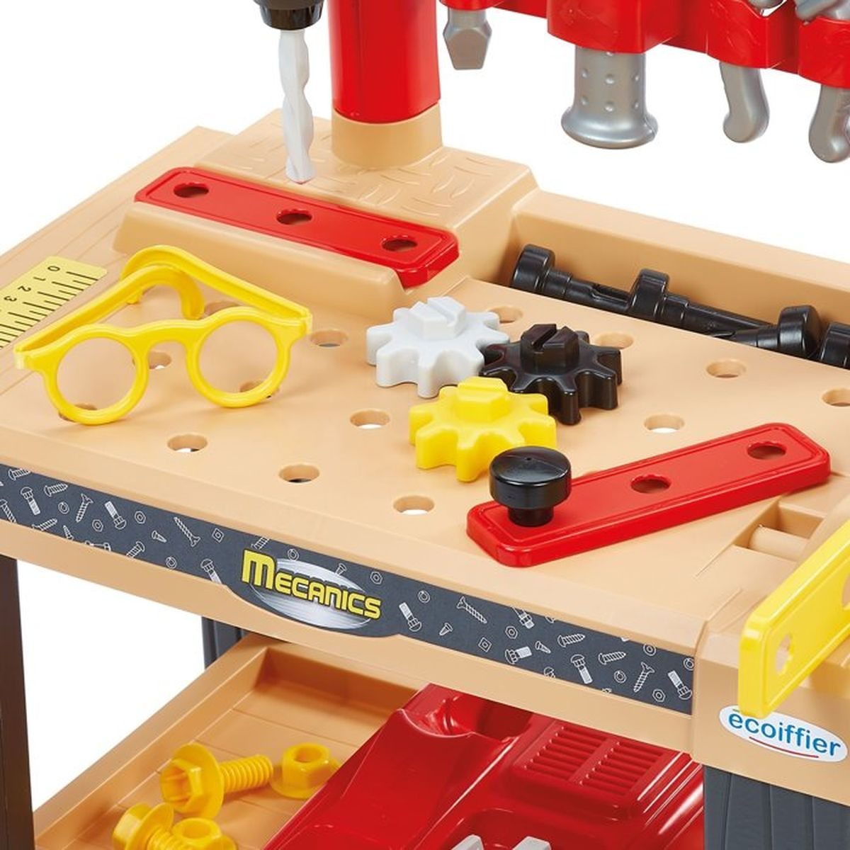 Werkbank mit Werkzeug: gelbe Brille, Zahnräder, Schrauben und Bohrer.