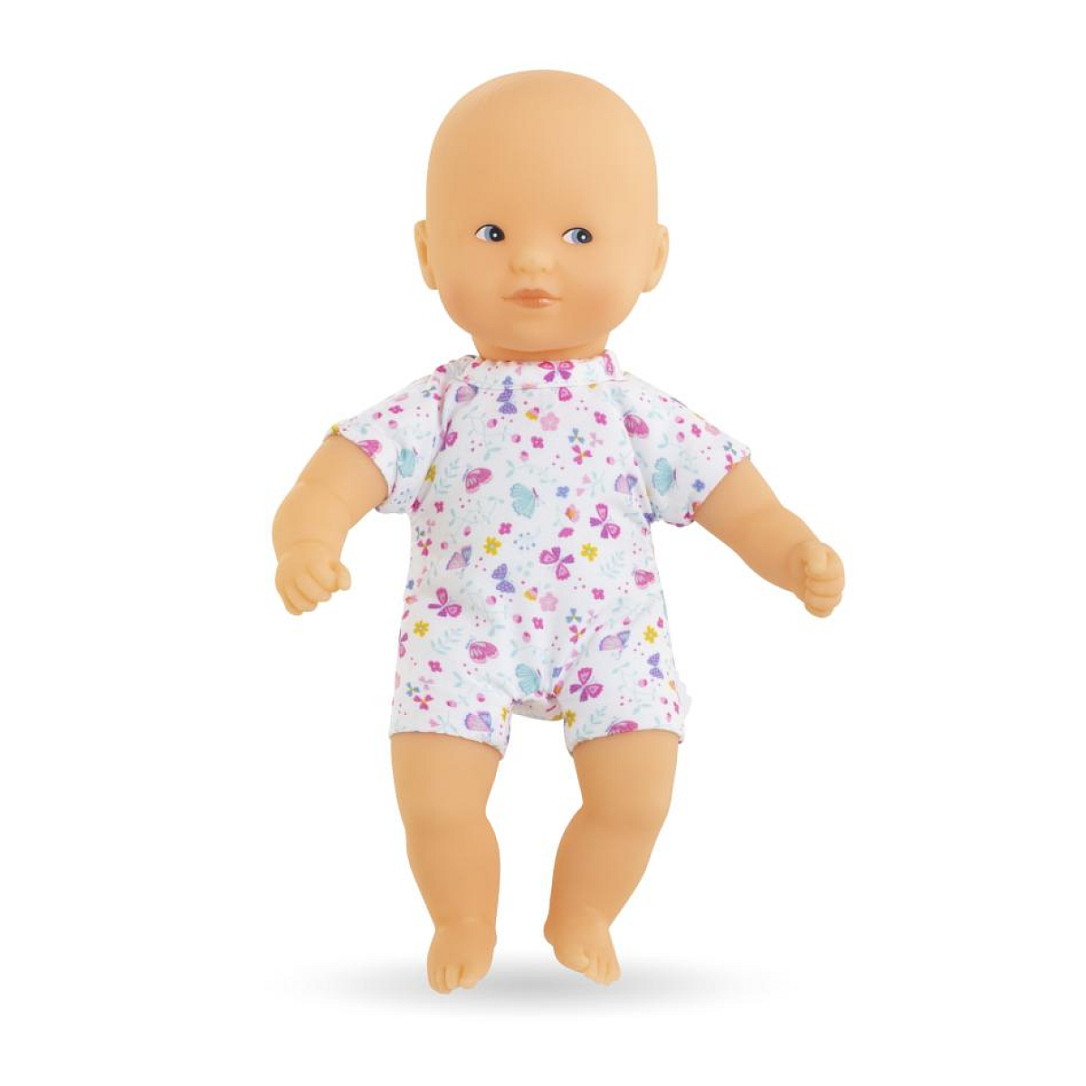 Eine Babypuppe mit blauen Augen und heller Haut steht aufrecht und trägt einen weißen, kurzärmeligen Strampler mit bunten Schmetterlingen.