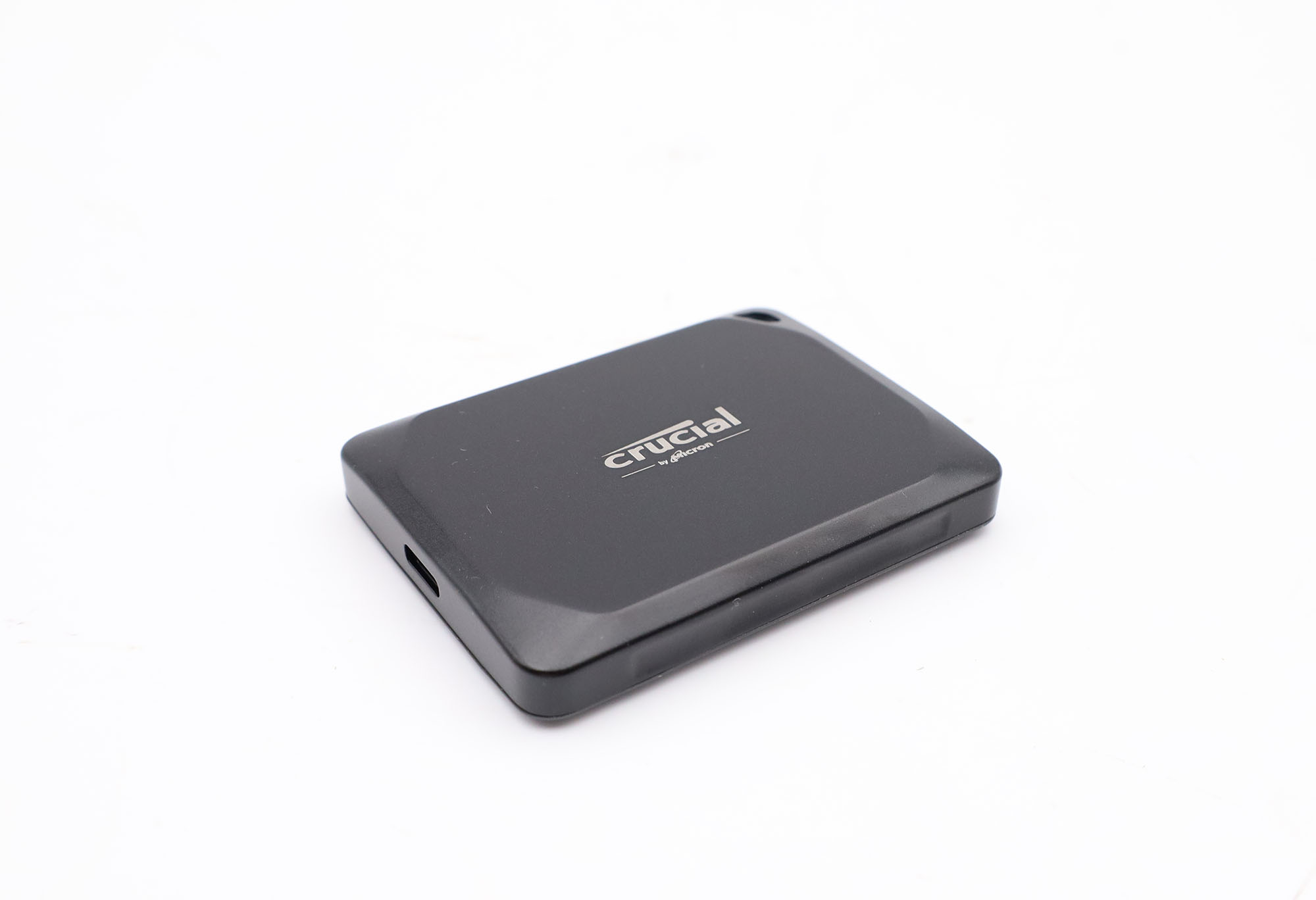 Ein schwarzes Crucial SSD-Gehäuse mit weißem Logo auf weißem Hintergrund.
