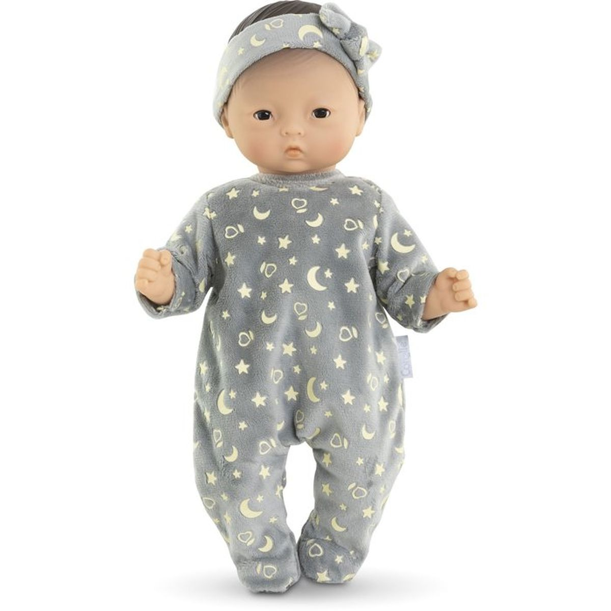 Ein Baby-Puppe in einem grauen Schlafanzug mit Mond- und Sternenmuster.