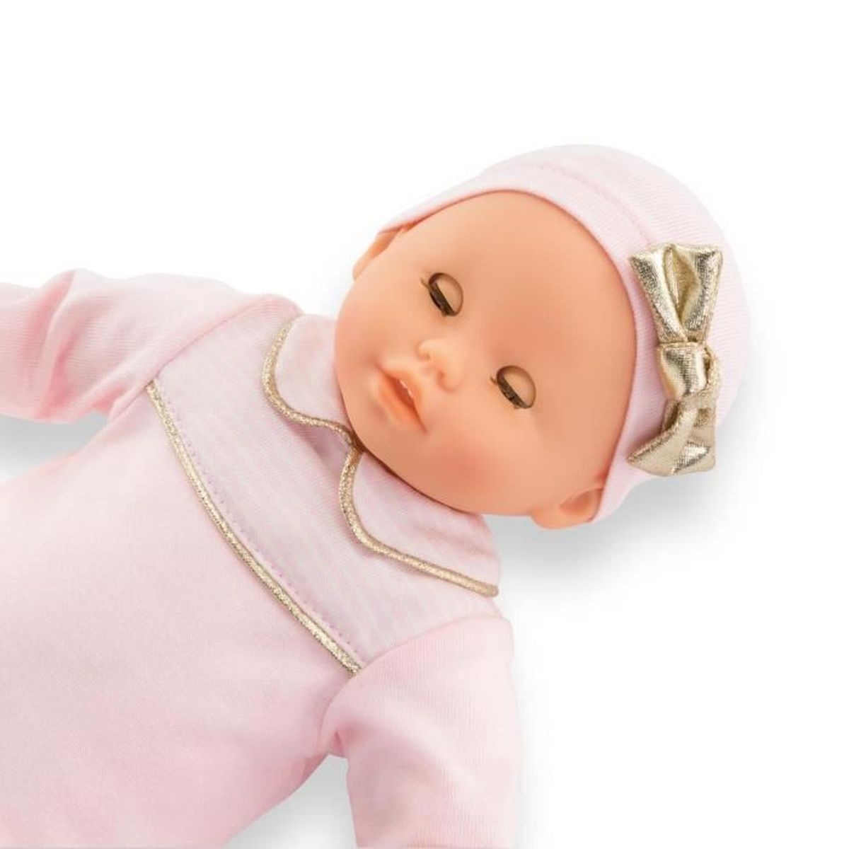 Eine Babypuppe in rosa Kleidung mit goldenem Band auf dem Kopf.