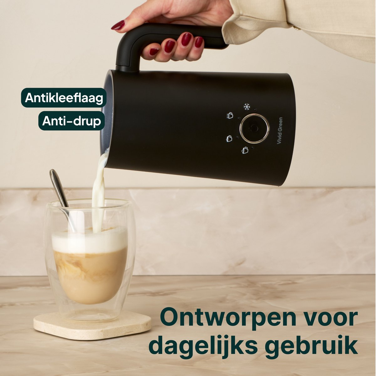 A black pitcher pours milk into a glass of coffee with foam.
