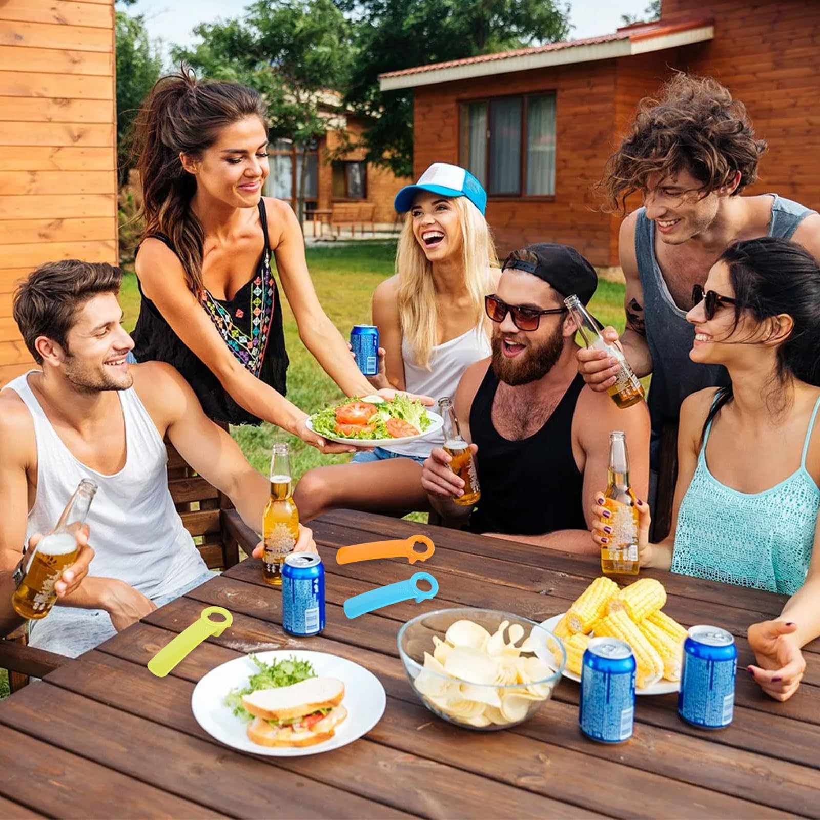Freunde trinken Bier und essen draußen am Tisch mit Snacks.