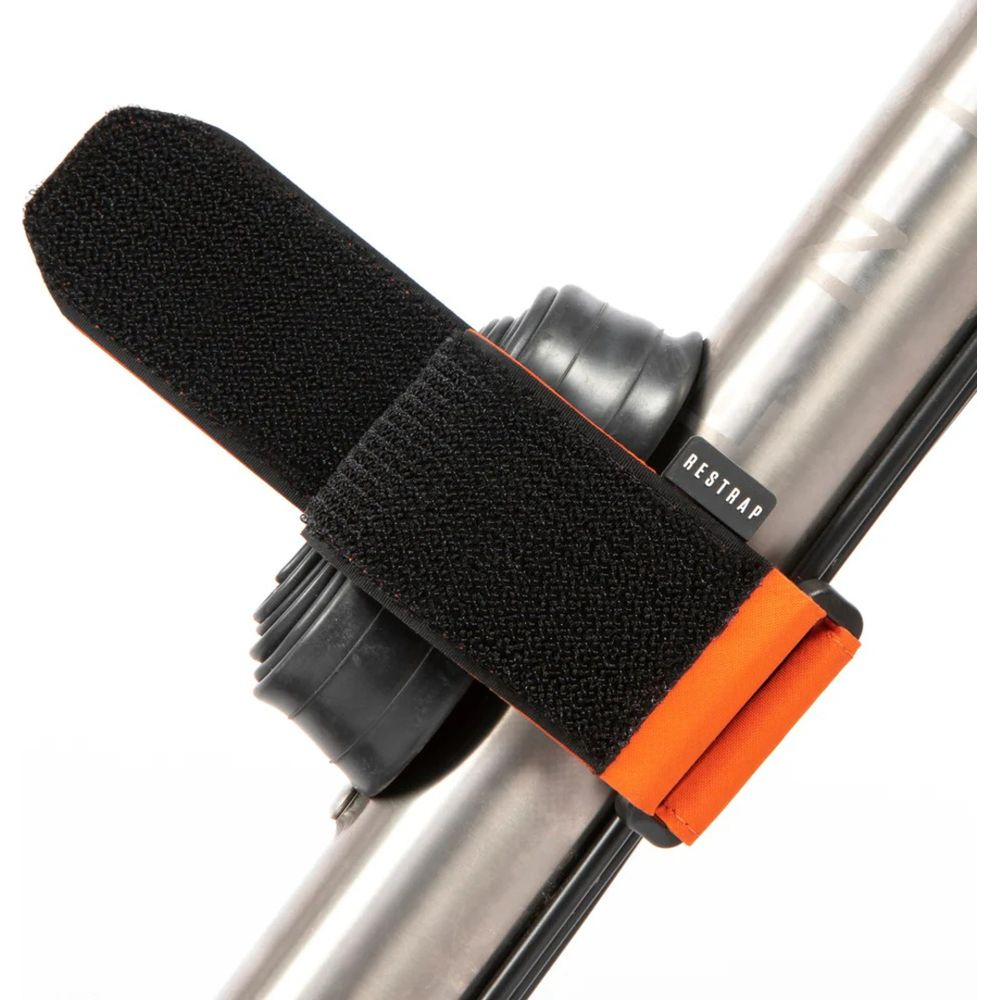 Une sangle velcro noire avec des accents orange est fixée à un tube métallique.
