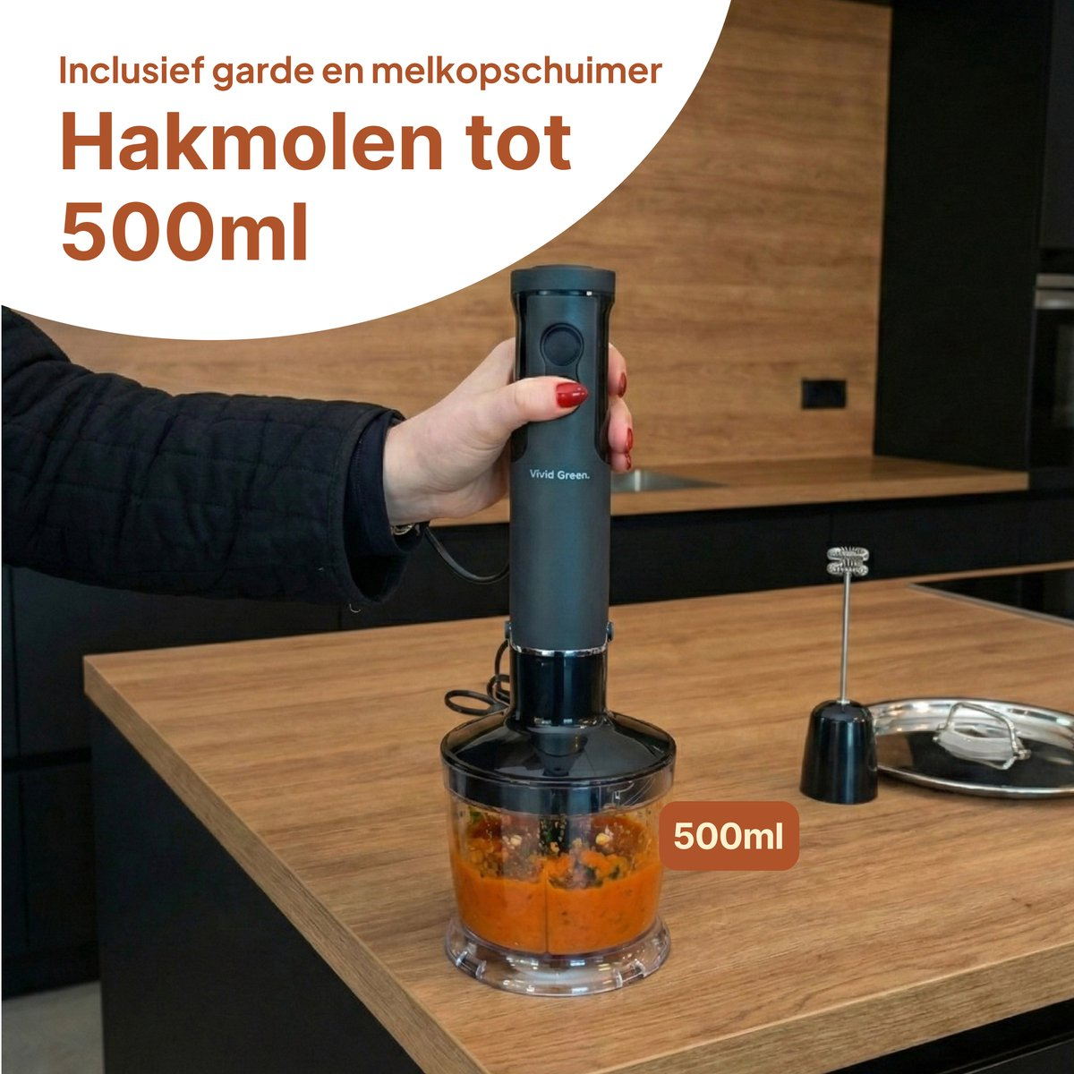 Hand blender with 500ml container with orange paste, on a wooden table.