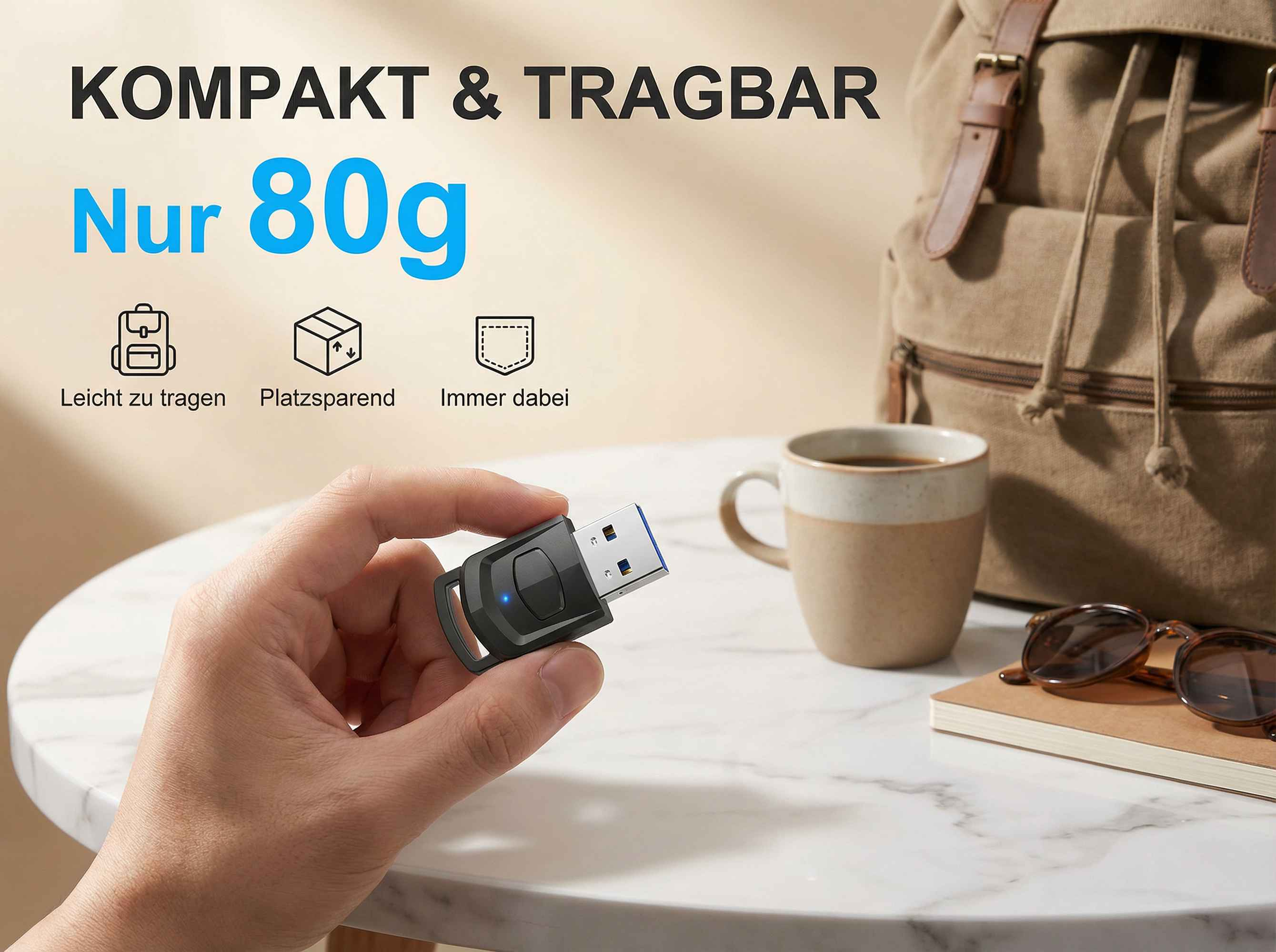 Ein Mann hält einen schwarzen USB-Stick. Ein Rucksack, eine Tasse und eine Sonnenbrille liegen daneben.