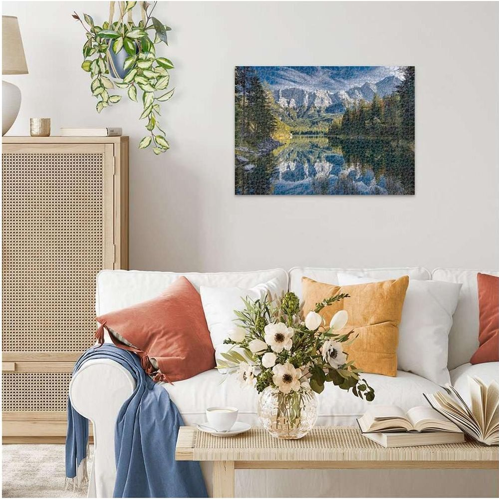 Berglandschaft mit See und Spiegelungen auf einem Puzzle an der Wand.