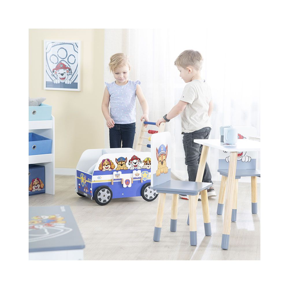 Due bambini giocano con un autobus giocattolo Paw Patrol e un tavolo.