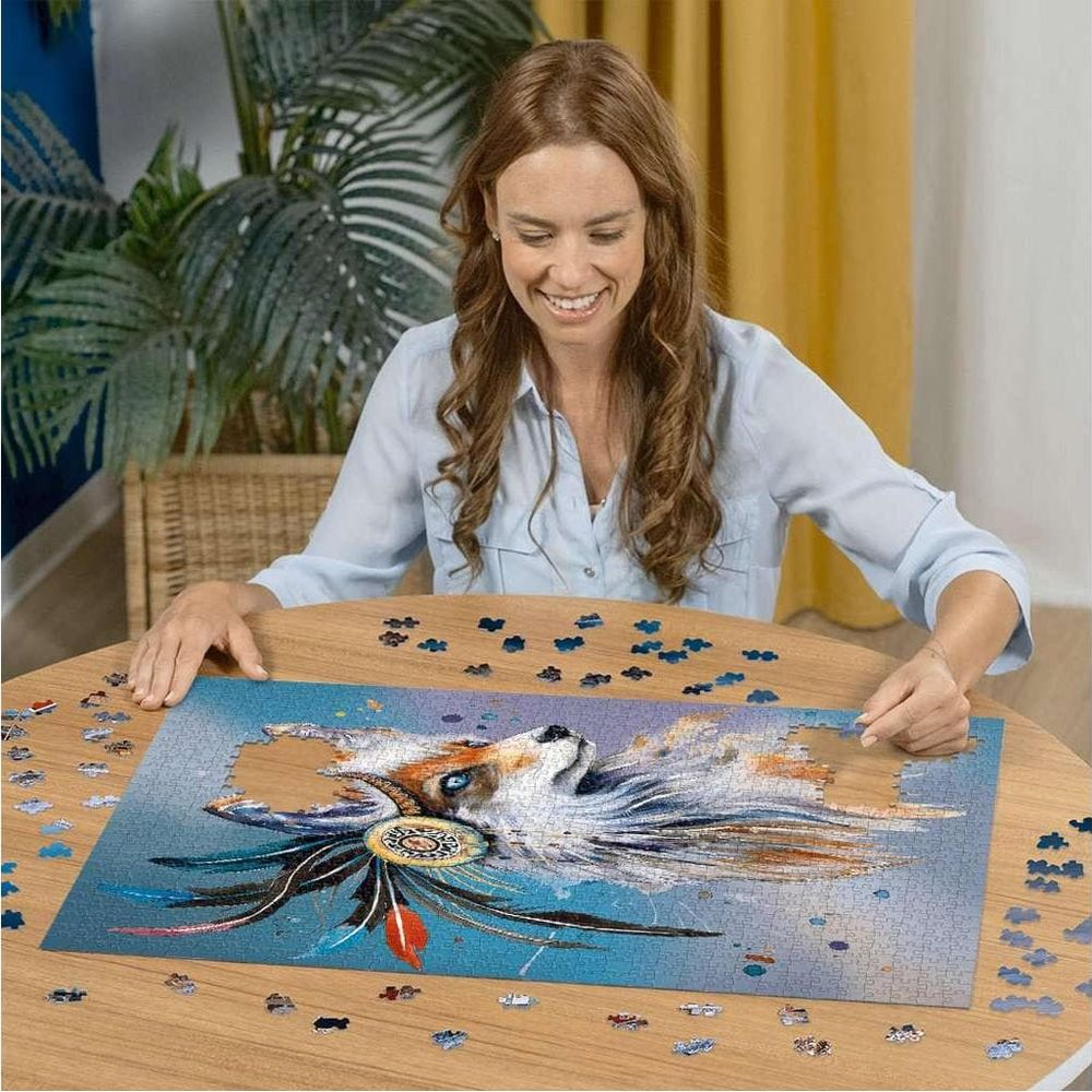 Eine Frau vervollständigt ein Puzzle eines Fuchses mit Federn und einem Traumfänger.