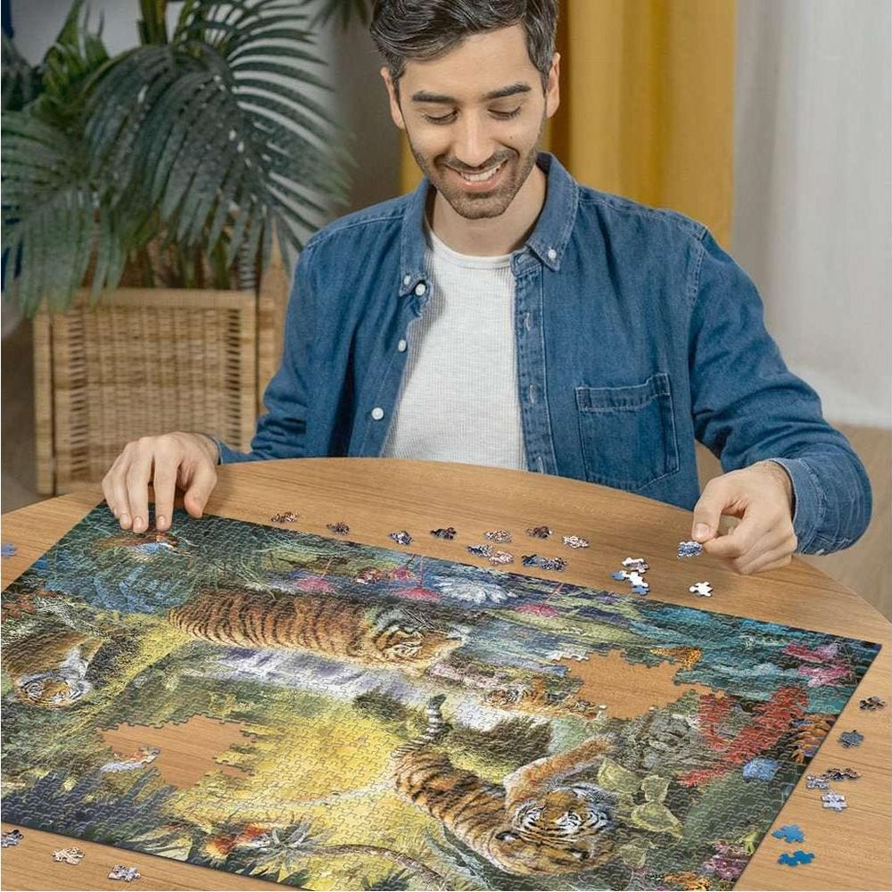 Mann vervollständigt ein Tiger-Puzzle auf einem Holztisch. Dschungelszene.