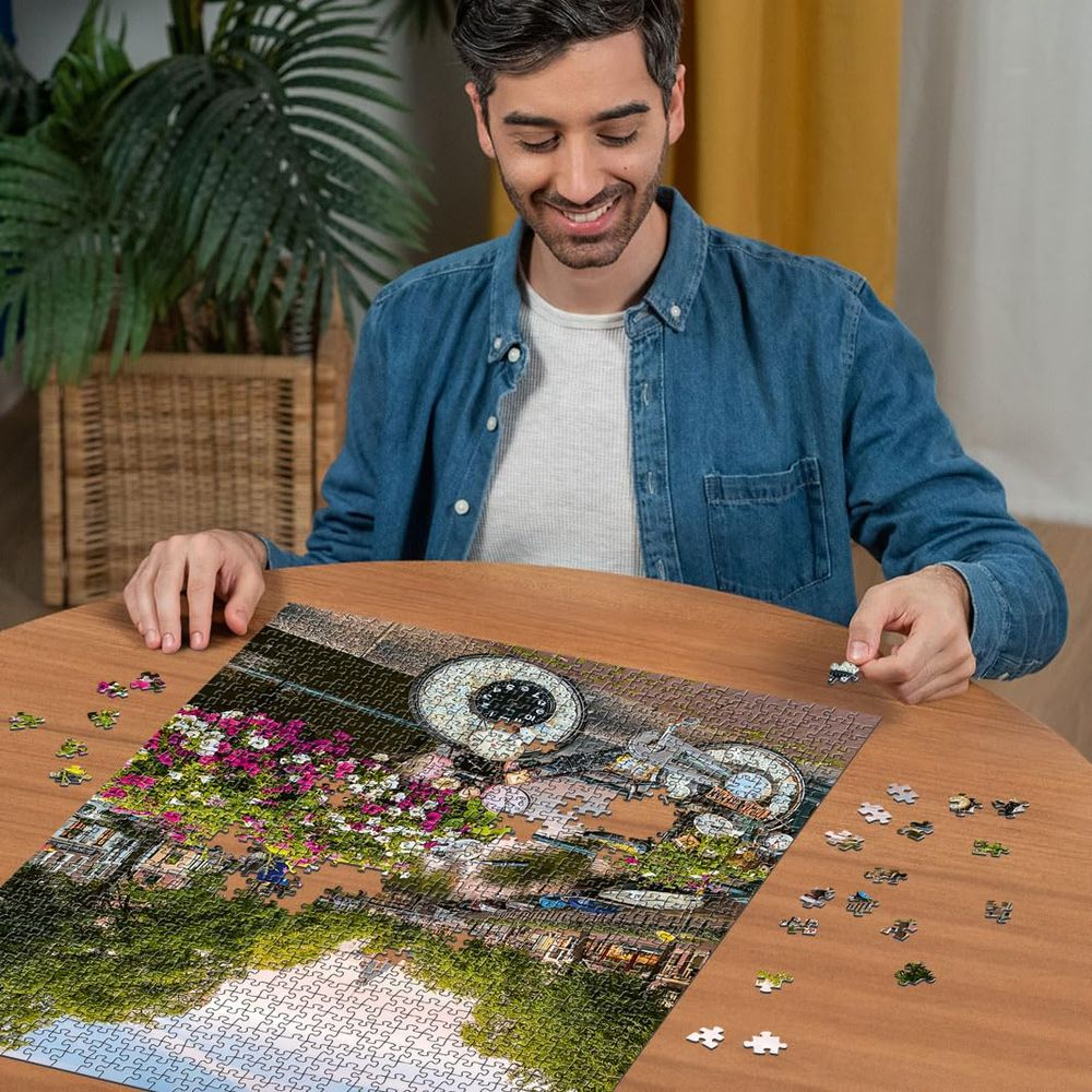 Uomo che monta un puzzle di bicicletta e fiori vicino a un canale.