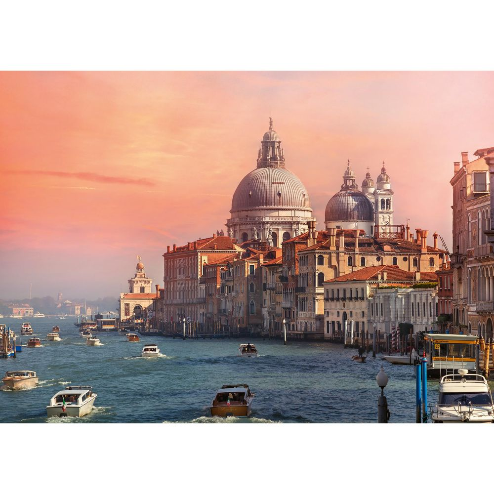 Boote auf dem Canal Grande in Venedig mit der Basilika Santa Maria della Salute im Hintergrund bei Sonnenuntergang.