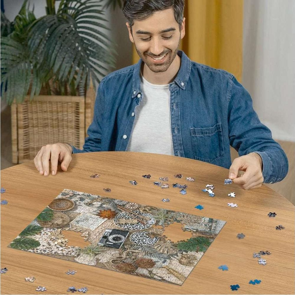 Mann löst Puzzle mit Kamera und Pflanzen auf Holztisch