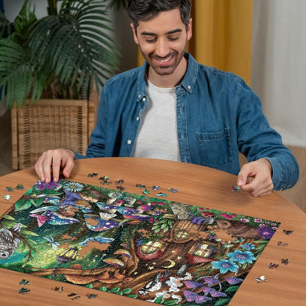 Uomo che monta un puzzle foresta fatata con casa sull'albero, farfalle e gufo.